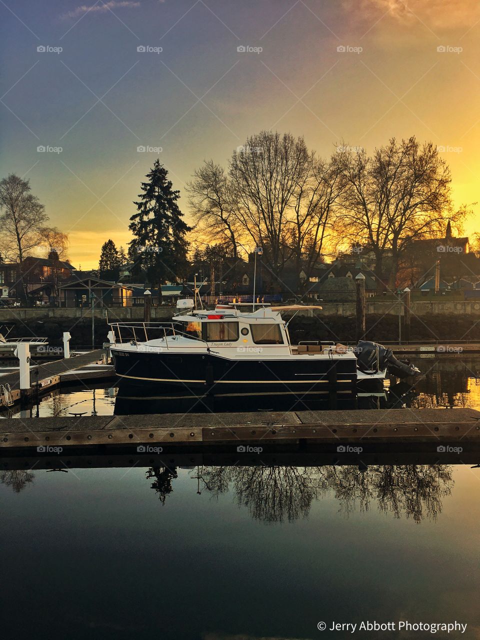 Beautiful Sunrise with boat and tree reflections on Liberty Bay and Marina in Poulsbo, Washington 