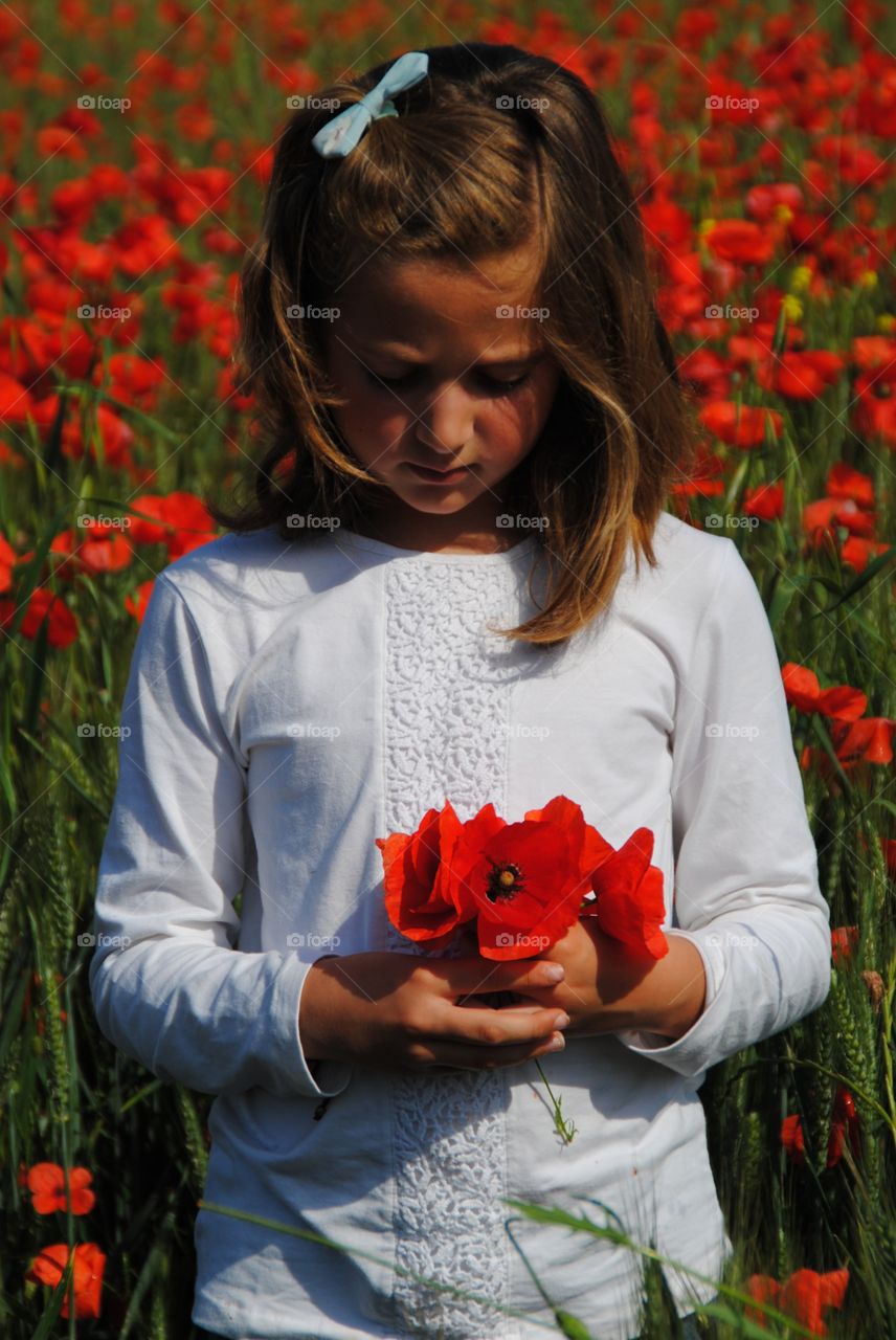 A girl with a bouquet of poppies