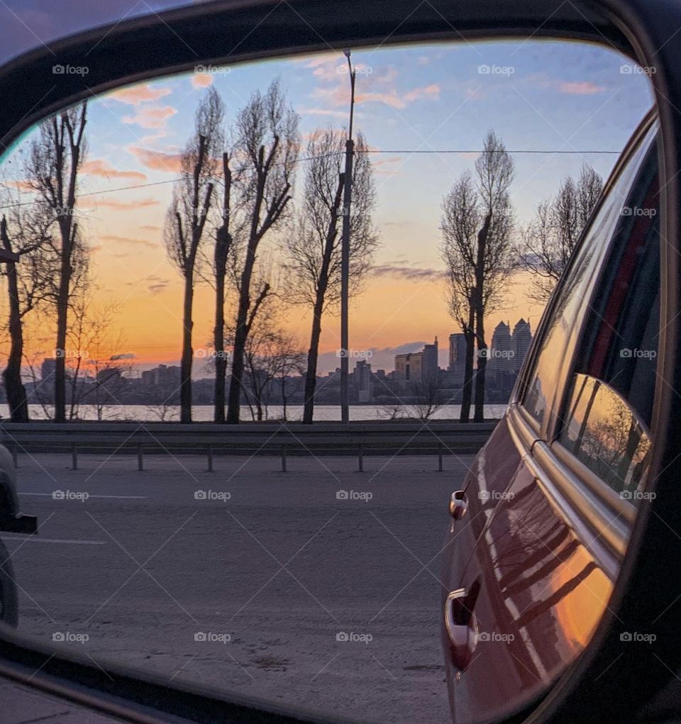 Road trip, sunset in a car mirror 