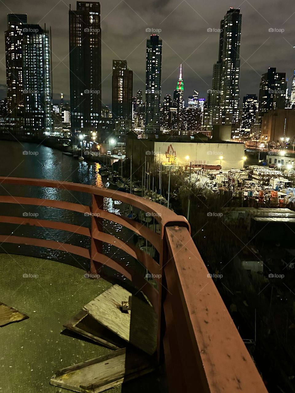 This is “Newtown Creek” at night seen from the “Pulaski Bridge” that connects “Greenpoint”, Brooklyn to LIC, Queens. In the distance we can see “Manhattan” including the “Empire State Building” and the “Kreisler Building”. 2023. Hypnotic Productions