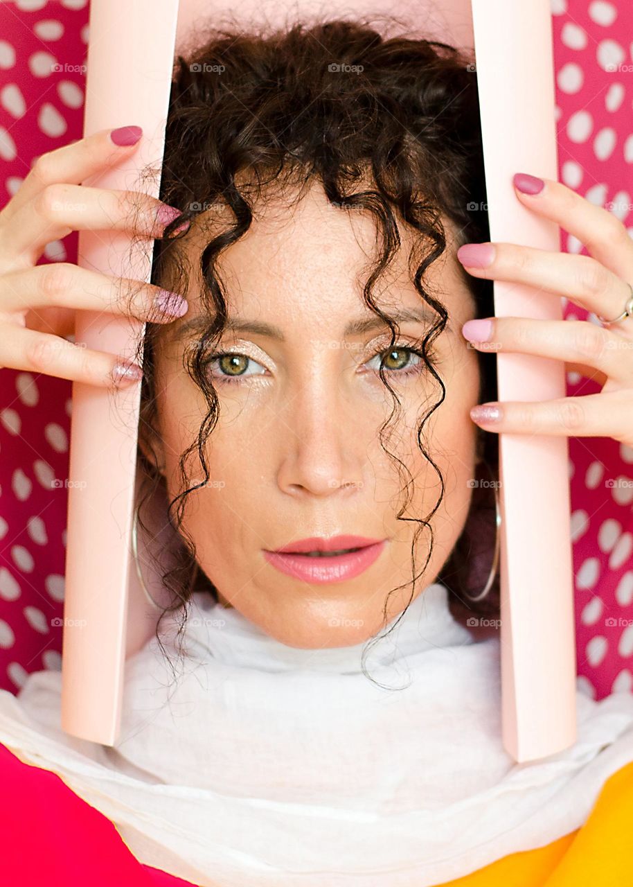 Portrait of a woman brunette on pink background