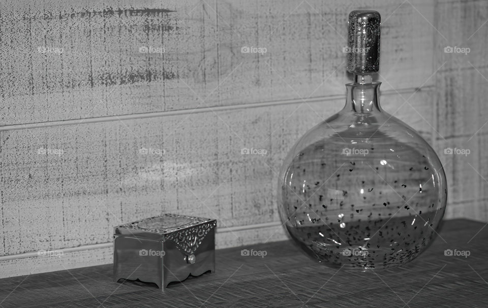 Living room ornament still life in monochrome. An empty glass vase and a small treasure chest. 