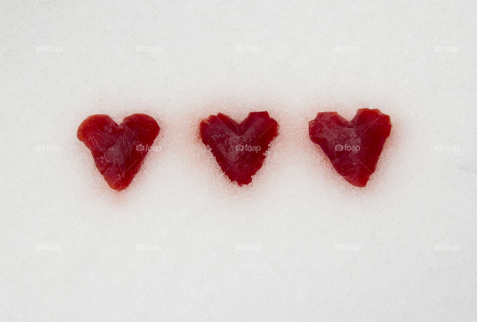 Three red hearts in snow
