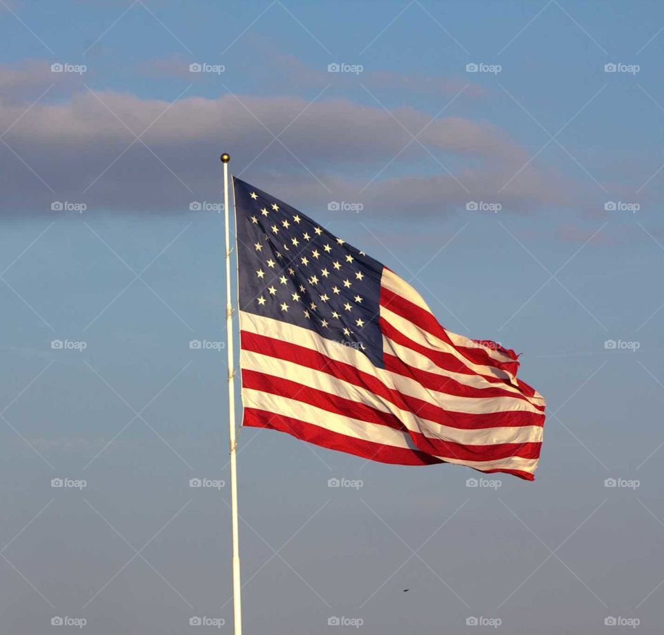 Old glory flying in wind amongst the clouds