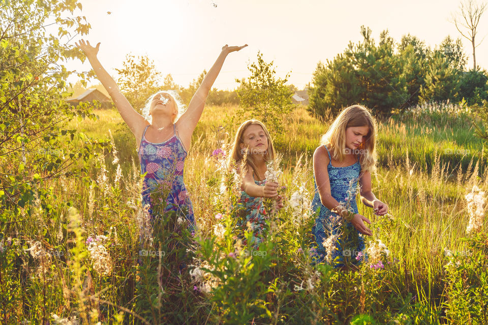 Summer vibes, girls are walking on the hayfield on the countryside