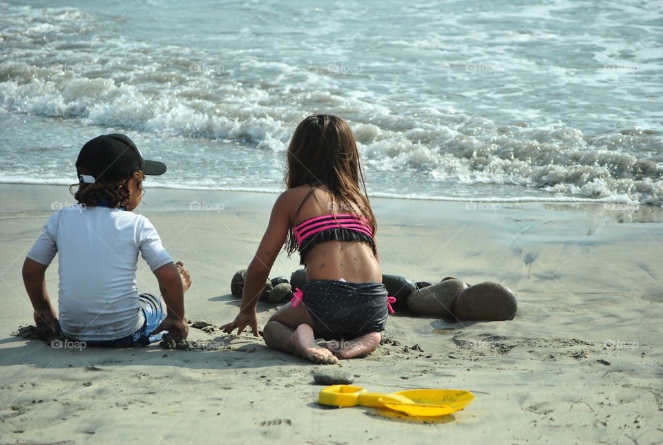 Children playing sand at the shore