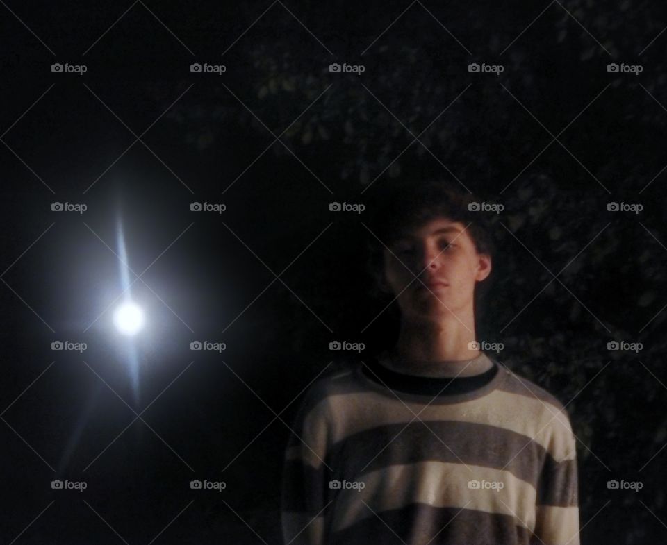young man under moon at night