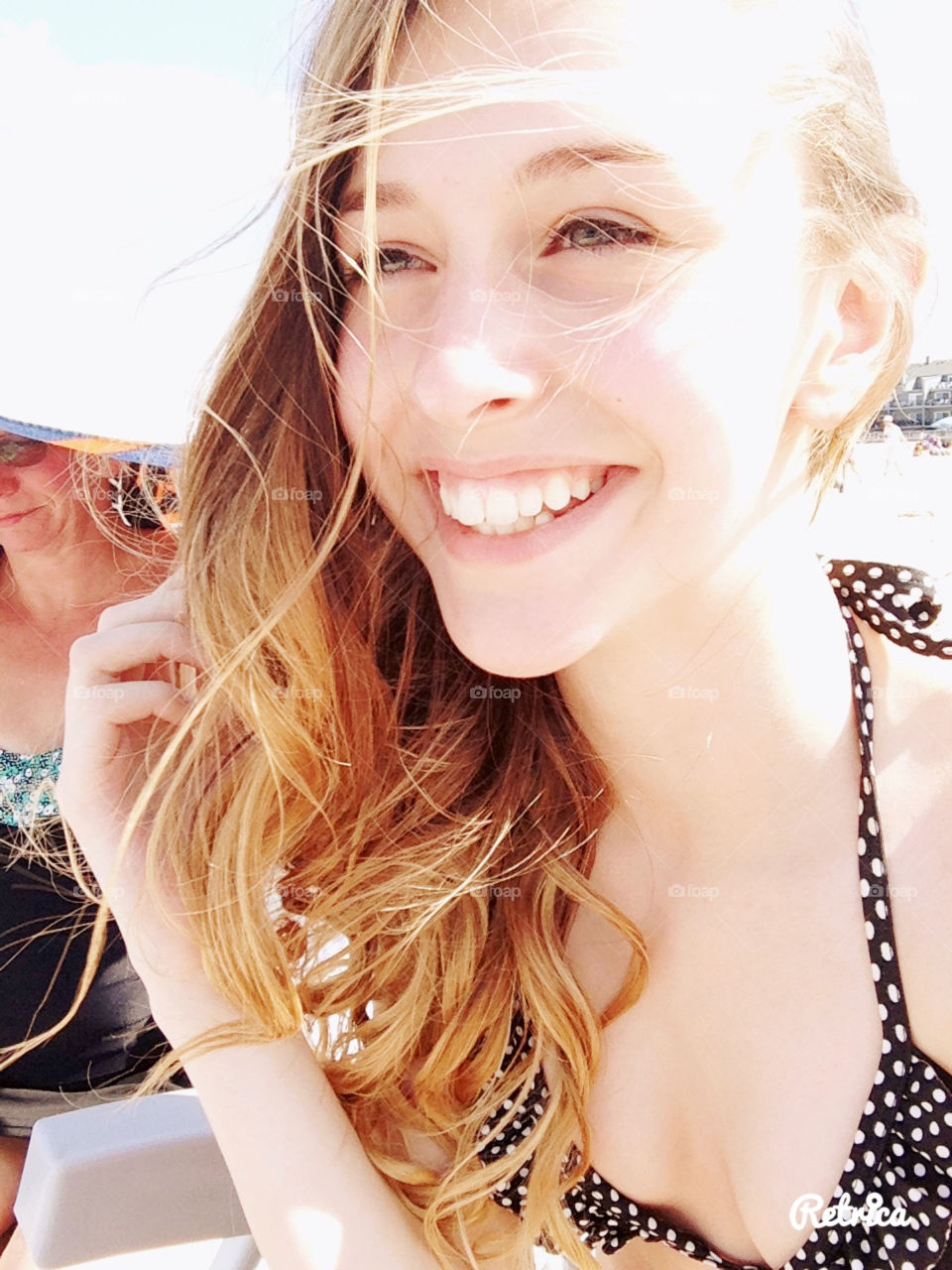 Summer at the ocean, pretty girl long hair blowing, smiling, Sunflare