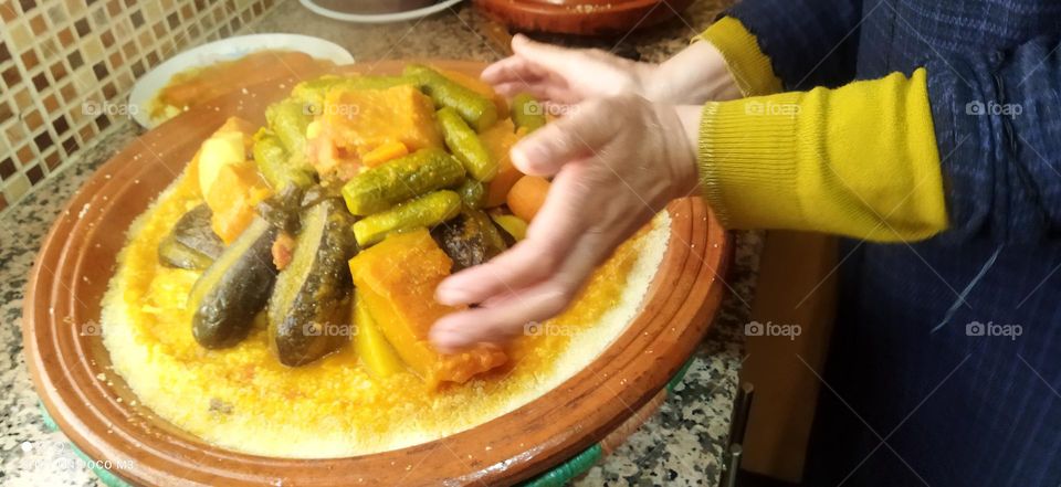 human hands and plate of COUSCOUS