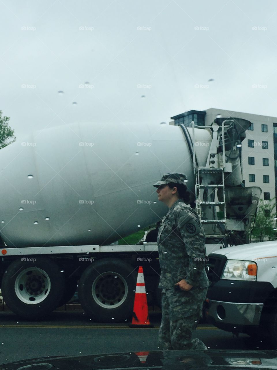 Military woman walking rain city traffic