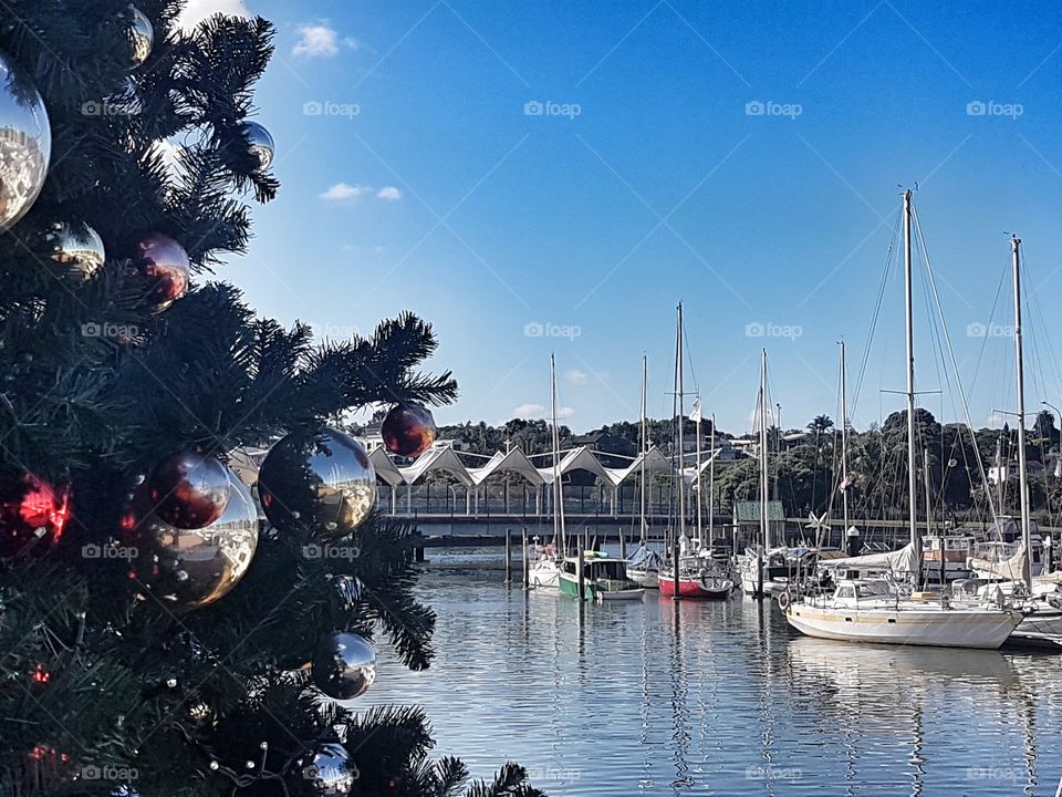 Christmas Tree on the harbour colour boats on the water summer sky