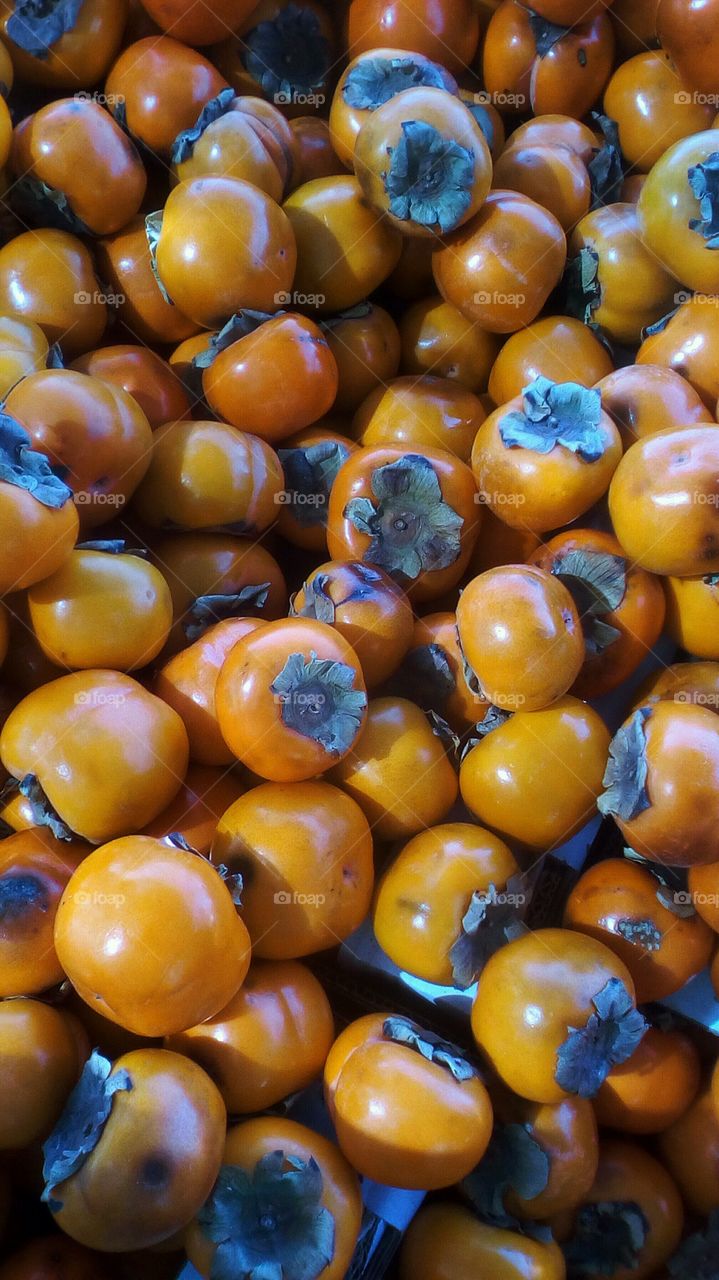 Abundence of round bright healthy sweet
fresh delicious persimmon in market