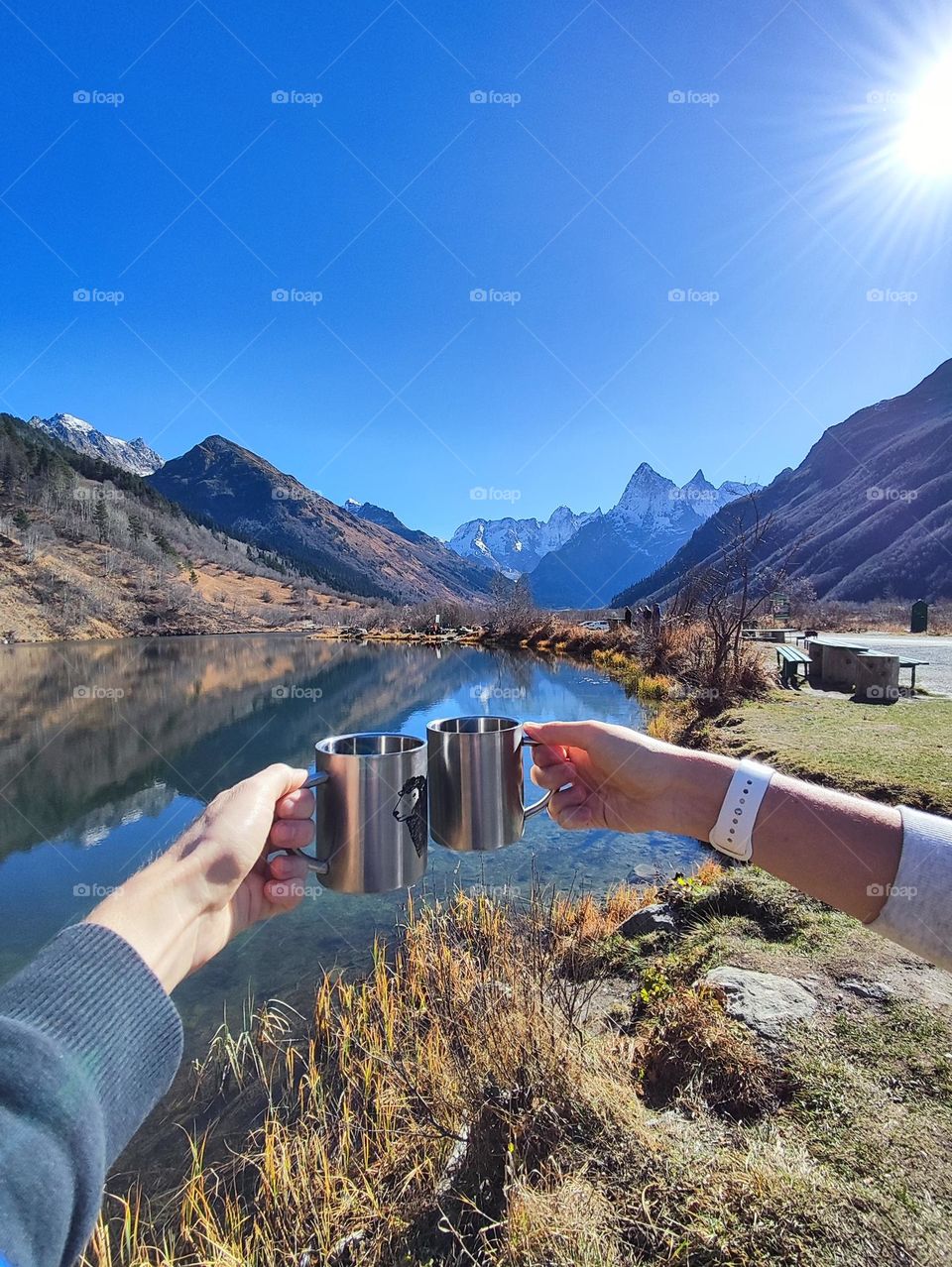 Two mugs on the background of a lake and mountains