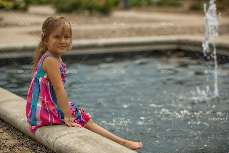 Girl sitting near the fountain