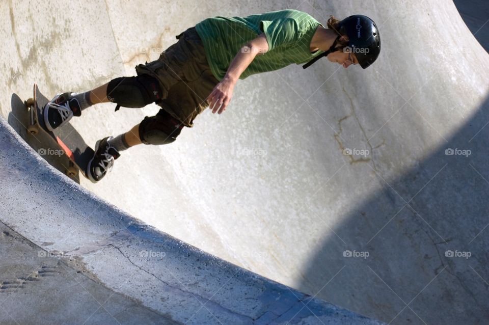 Skateboarder drops into a skate bowl