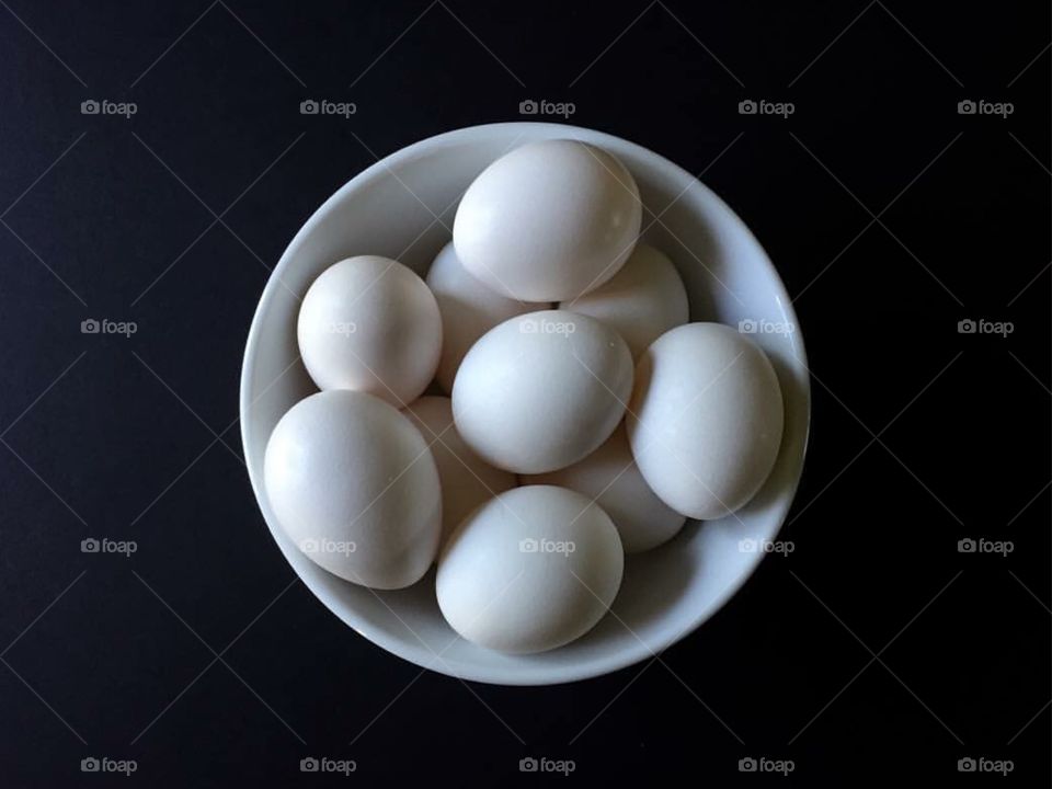 Eggs in White Bowl on Black. White eggs in white bowl on black background 