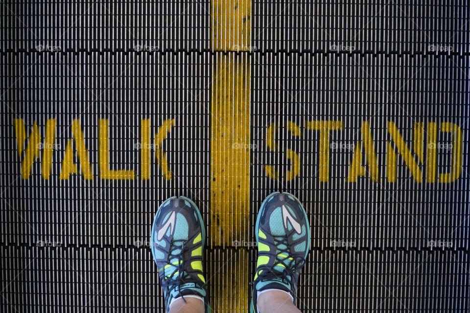 Low section of a person standing on escalator