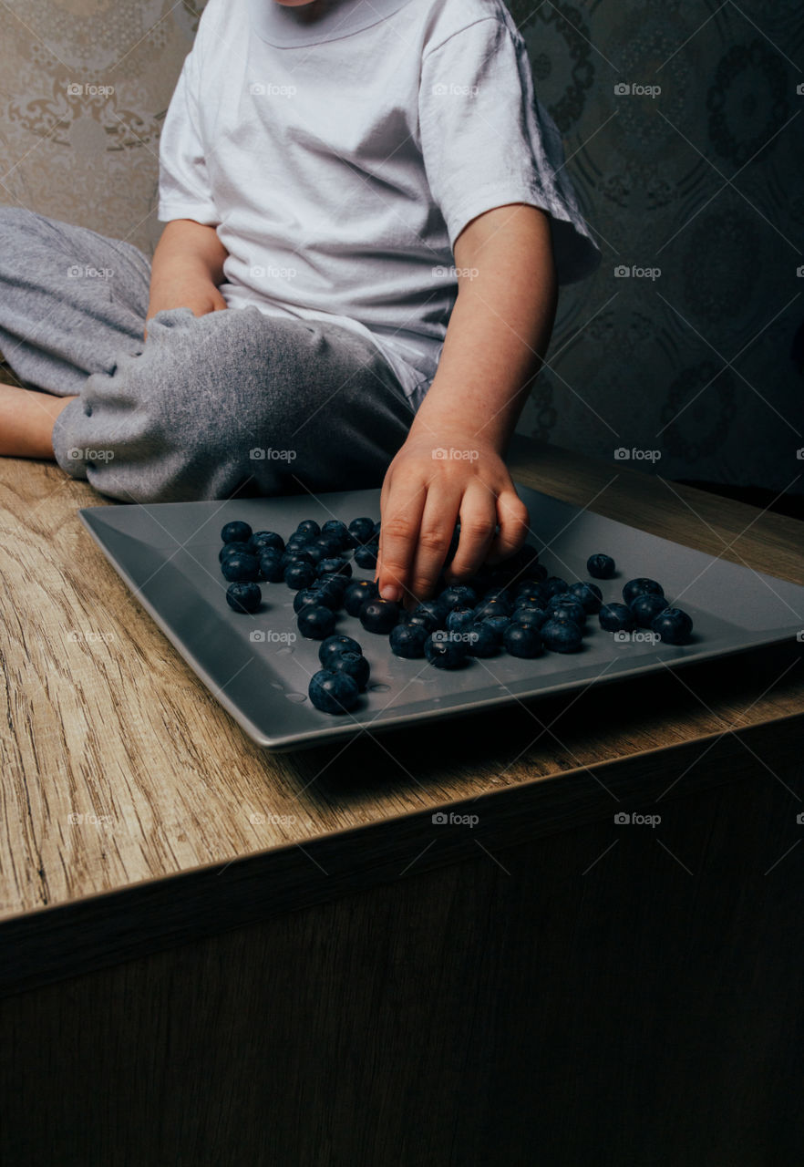Hands and plate with blueberries