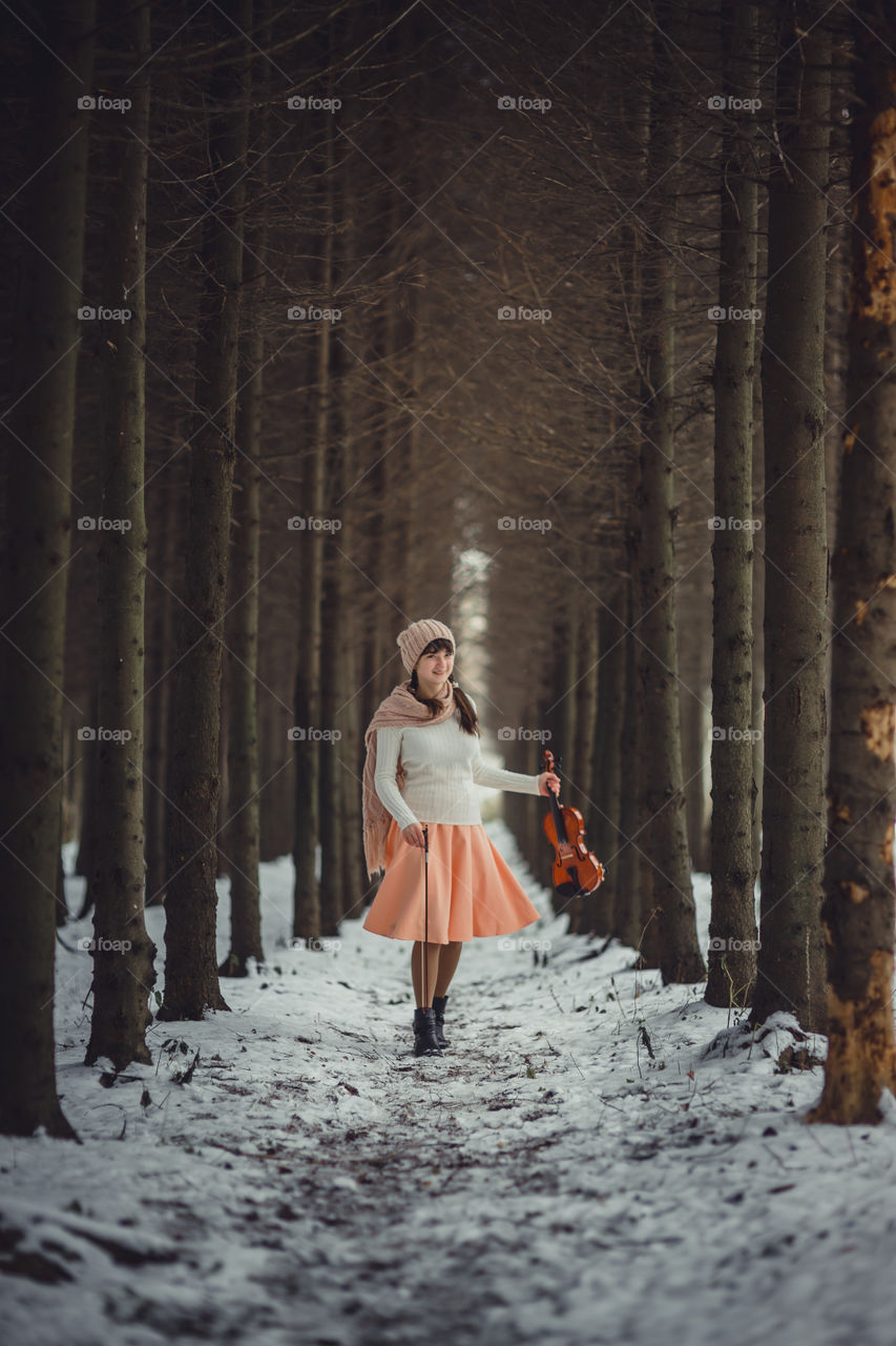 Teenage girl portrait with violin in winter park