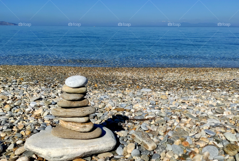 Balancing stones on a beach in summer