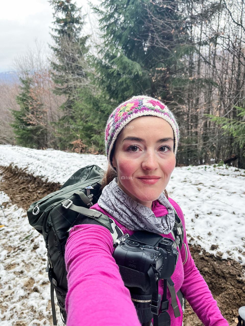 Beautiful smiling woman while hiking in the mountains, at the beginning of winter.
