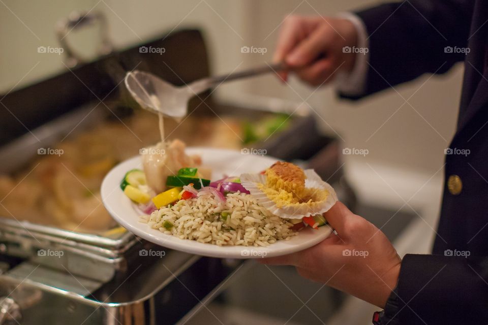 Man holding plate and serving self
