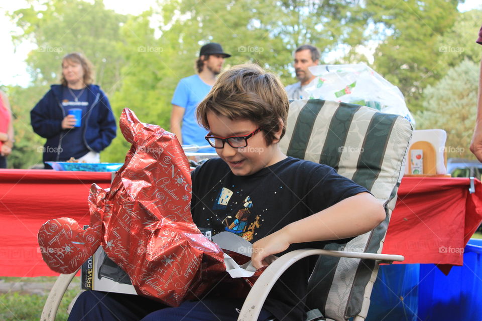 A young boy rips open his gift with excitement