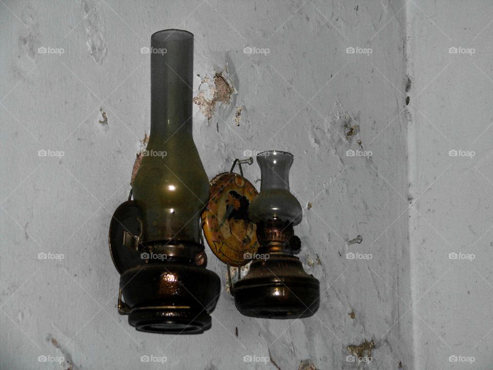 two ancient oil lamps hanging on the wall were somewhat dull and shabby