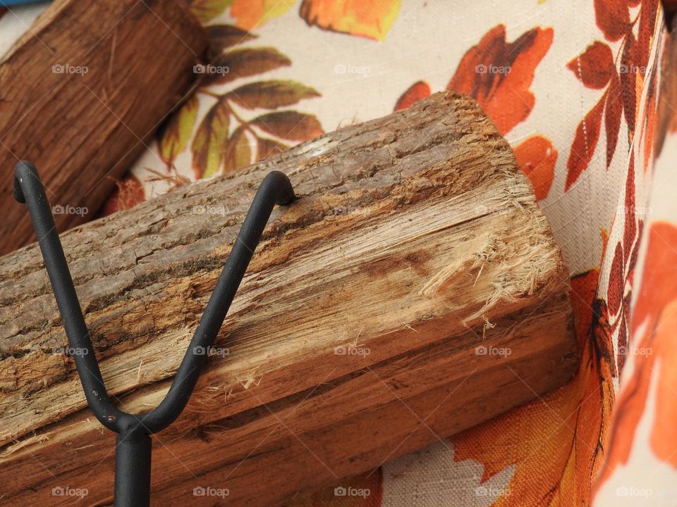 Autumn fall decor and cloth with logs and fire grate closeup with orange drawings of leaves.