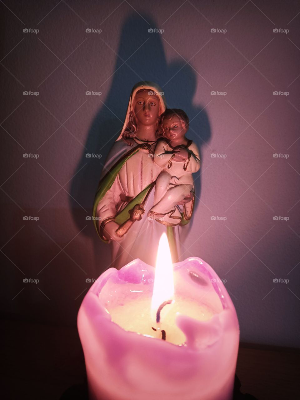 pink candle and religious statue