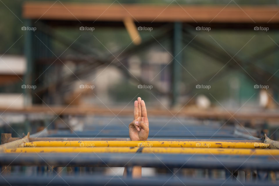 Hand with three fingers come out from the construction site