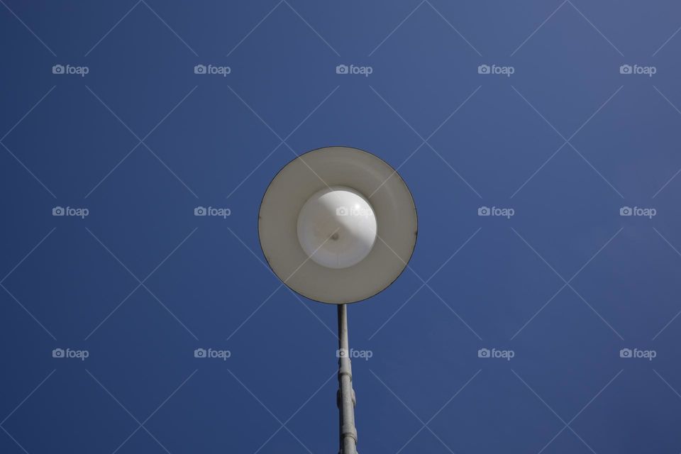 Low angle view of street lamp against blue sky