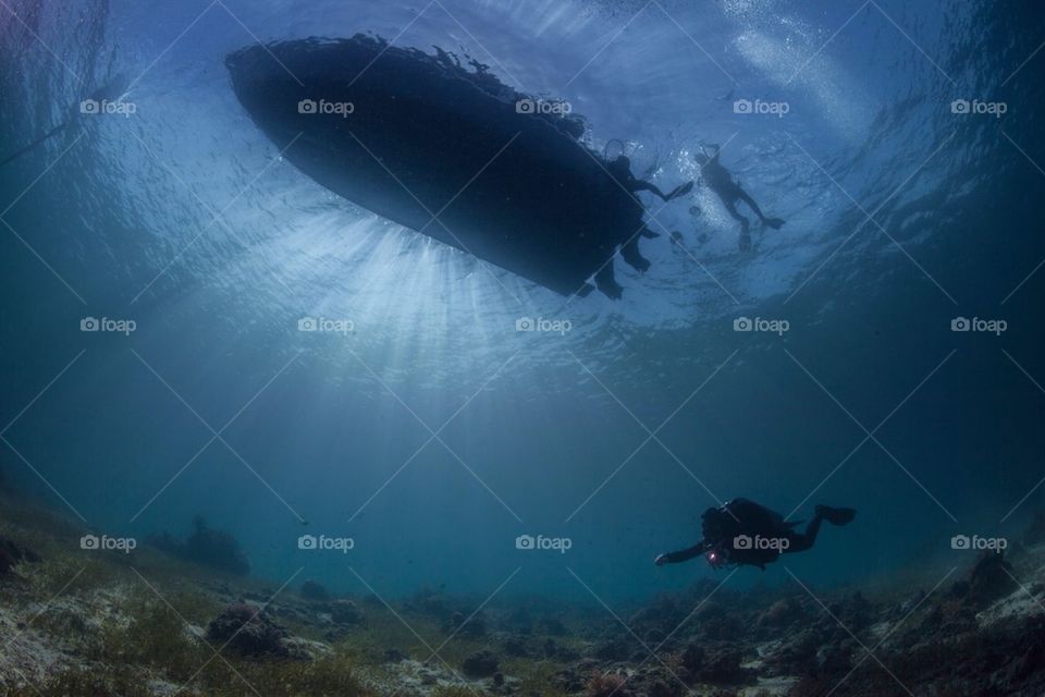 Diver under a boat silhouette 