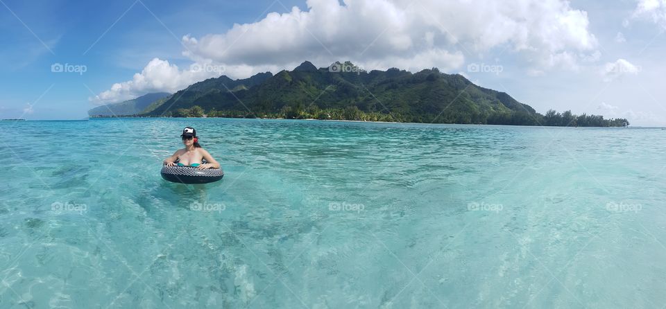Islandgirl in warm clear beautiful water in paradise island, moorea, near tahiti.