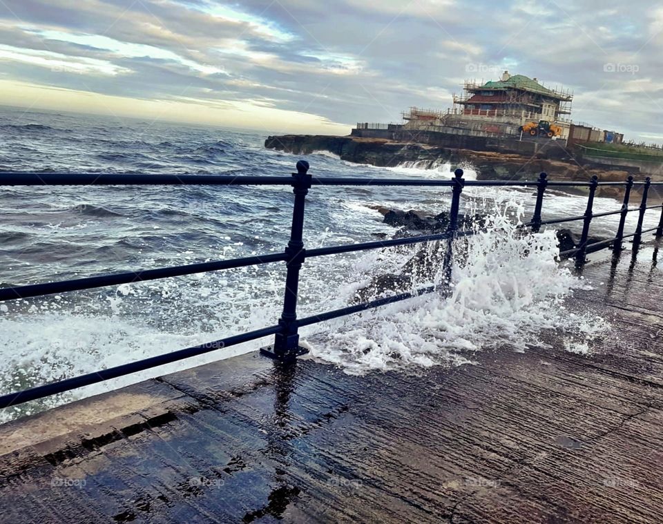 Rough sea with crashing waves on Amble Pier.