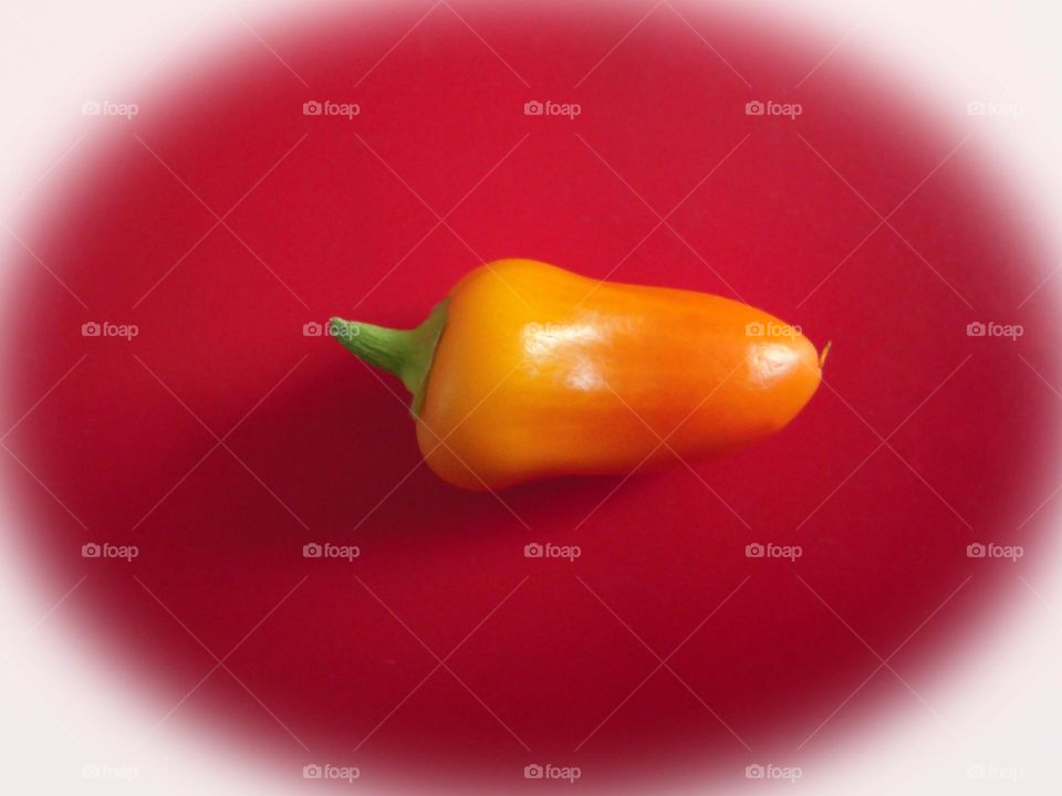 Small pepper unique vegetable on red surface ..