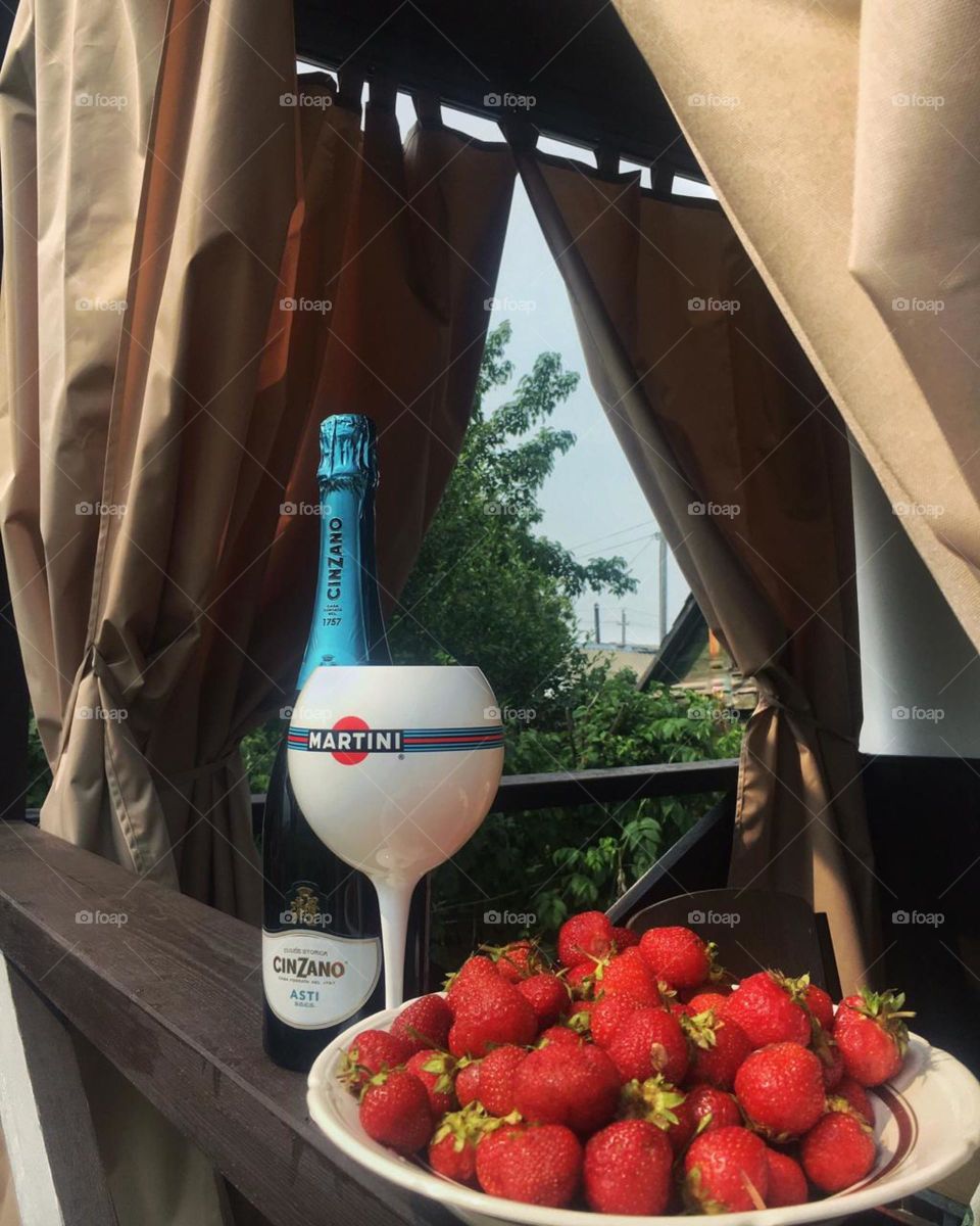 ягода бокал и бутылка вина на летней терассе