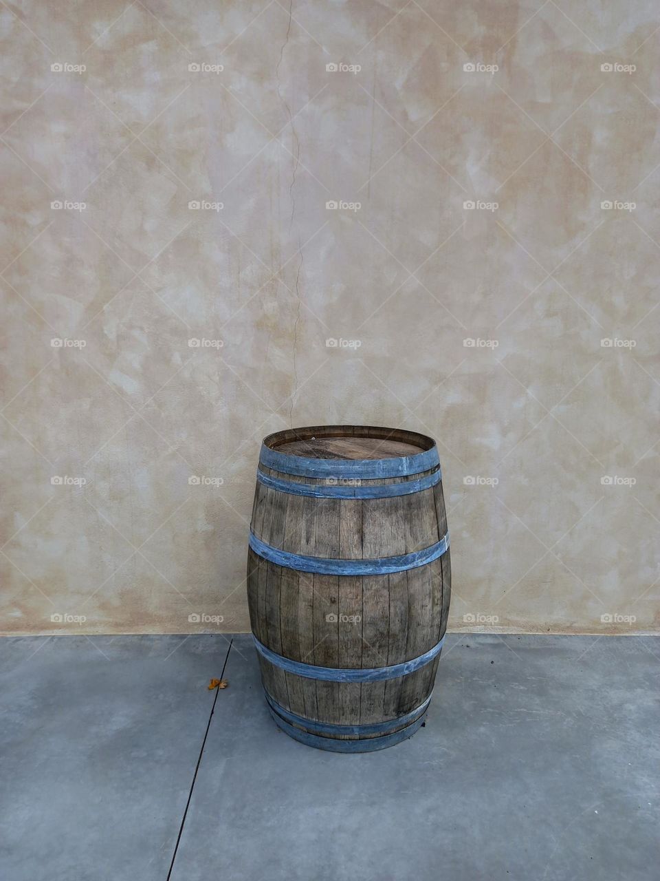 A barel 
in front of a wall