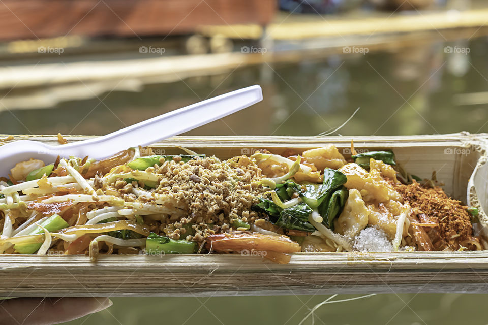 Fried noodle with spring onion and bean sprouts in bamboo.