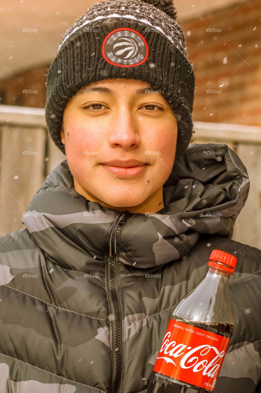 Happy teenager with a bottle of coca cola