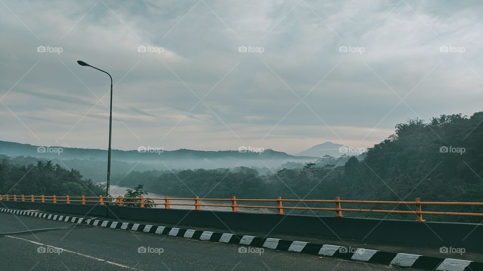Bridge with mountains and clouds in the background