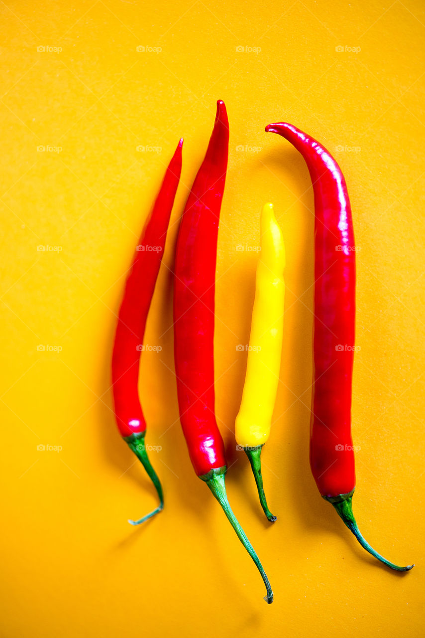 Red chilli pepper on yellow background
