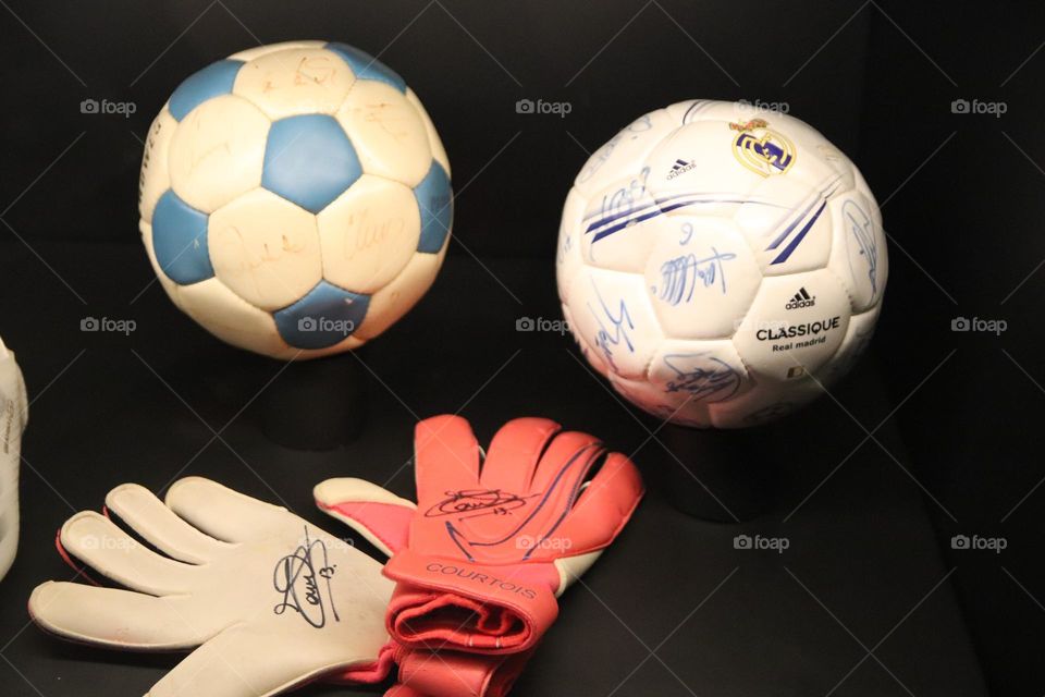 A football gloves and the balls sign by a historical players of a "football club Real Madrid", exibited in "the Stadion of the Real Madrid museum"