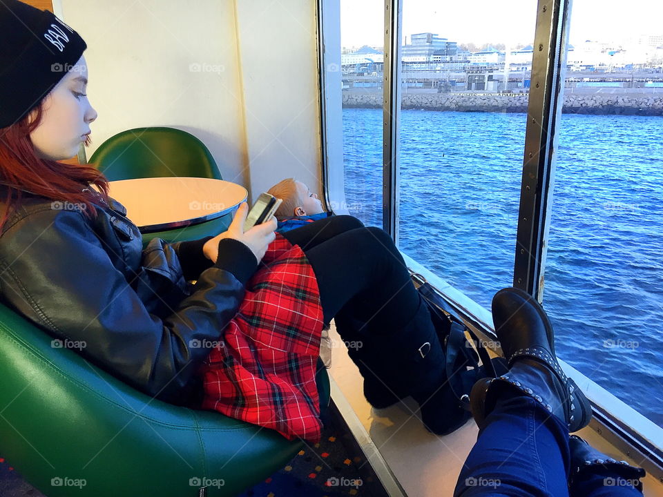 Girl on a ferry using her phone