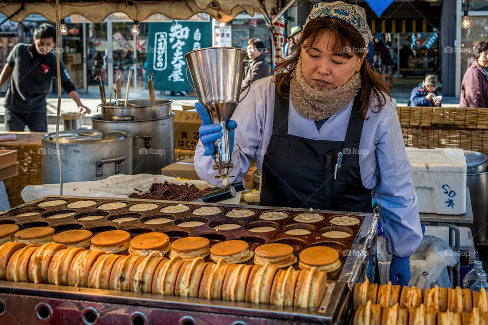 Seibu-Chichibu, Tokyo, Japan - December 3, 2014: Lady in street stall making dorayaki; the popular Japanese red-bean paste sweet pancake.