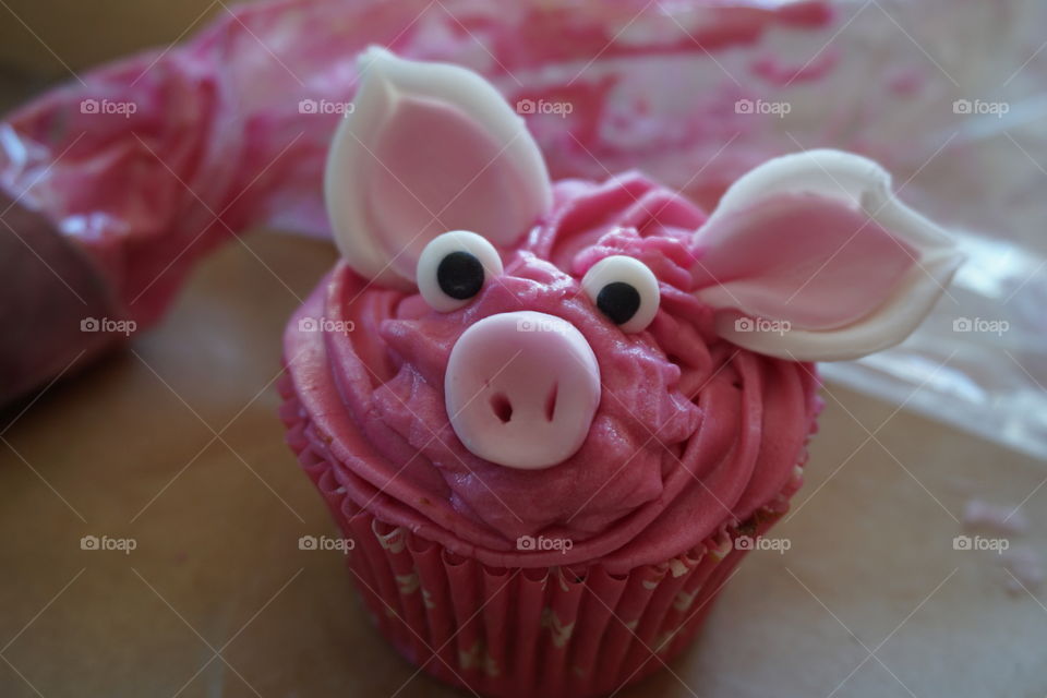 Shocking pink icing is  piped onto a small cake and eyes, ears and snout added to make this pretty pig fairy cake 🐷