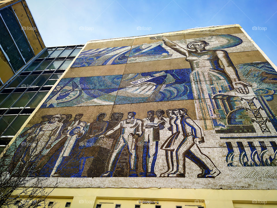 Mosaic on the wall of the house.  Close-up woman and people of different professions