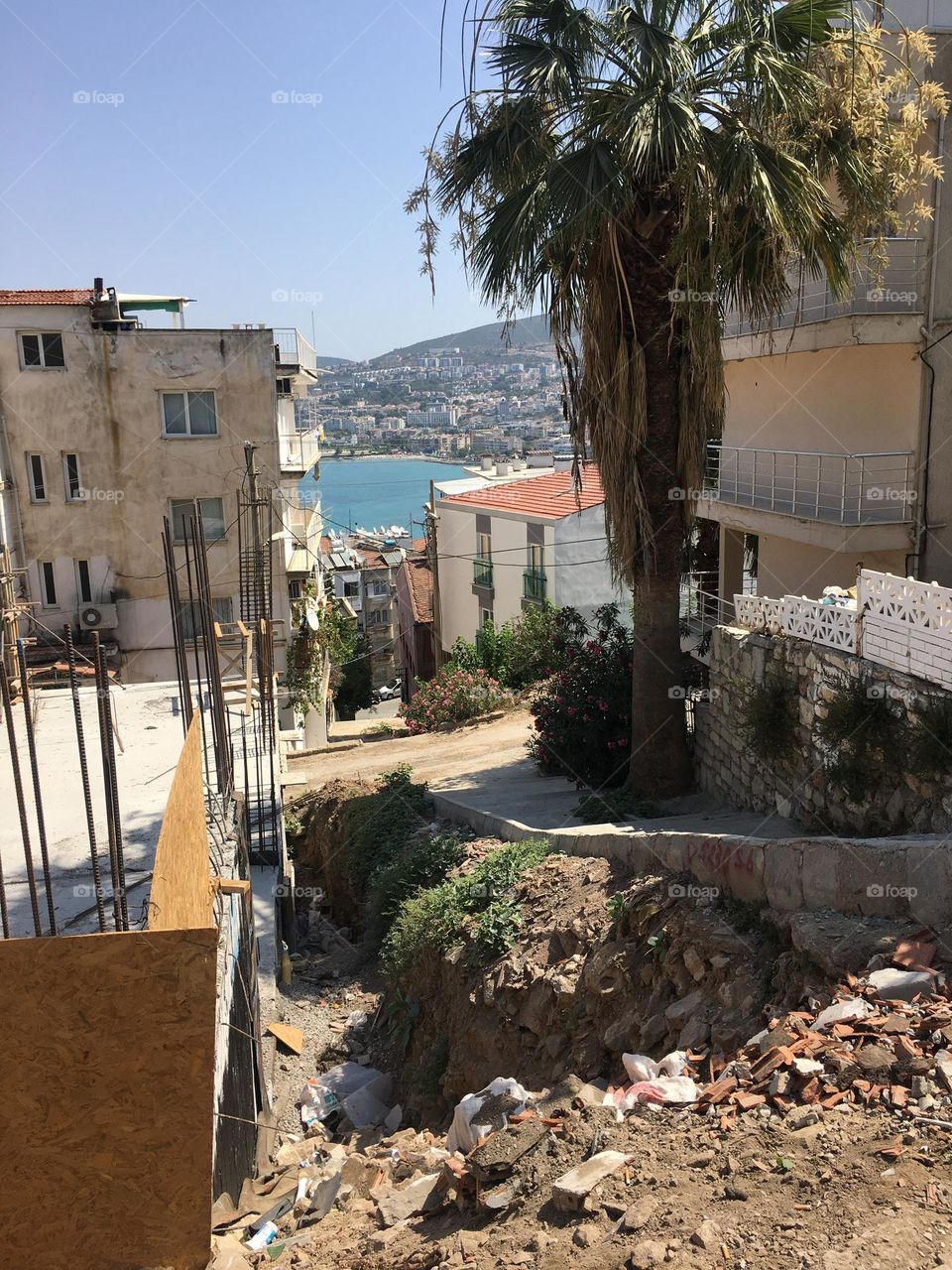 Sunny holidays I’m Turkey. Walk in the cute city and charming streets by the beach in Kusadasi. perfect blue sky and ocean view. Beach and the shore. To travel is to live. Gorgeous tall palm trees.