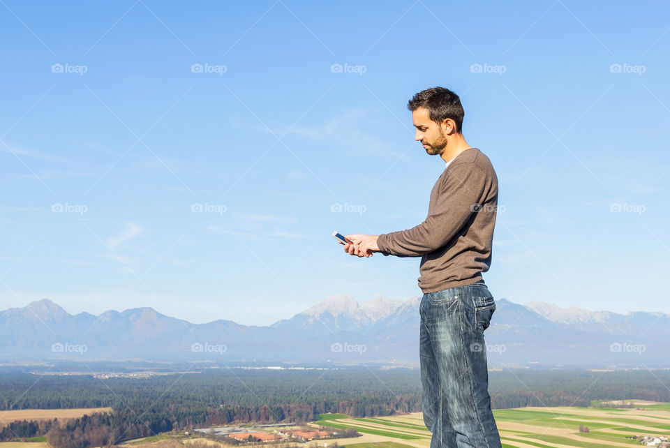 Man standing with mobile phone in hand