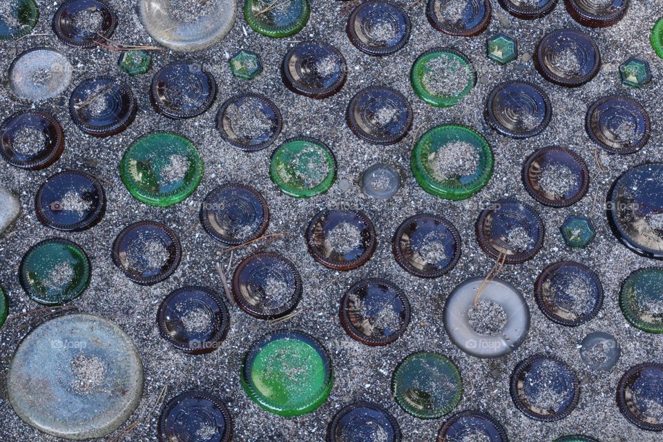 Glass bottles, wine and beer, sunk in sand with bottoms up. Located at the Oregon Coast.